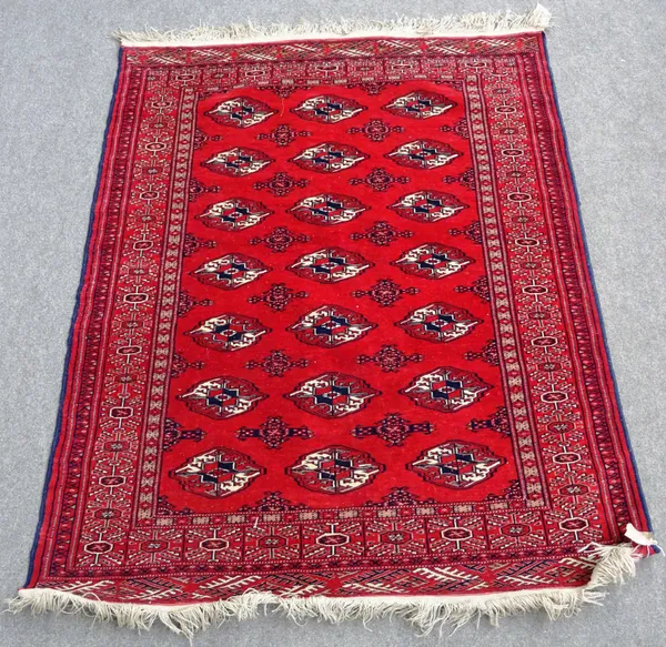 A Turkman rug, the madder field with three columns of seven guls, supporting crosses, a madder sunburst border 163cm x 127cm.