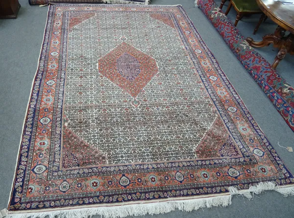 A Bidjar carpet, Persian, the ivory carpet with a madder diamond, pale madder spandrels, with an intricate 'herate' design, a pale madder palmette and