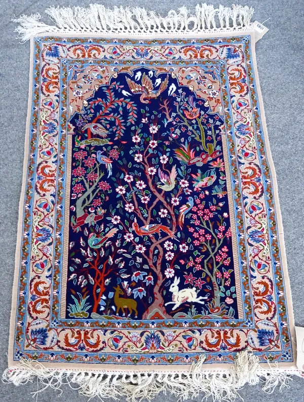 A fine part silk Esfahan prayer rug, Persian, the indigo mihrab filled with trees filled with birds and animals, a pale beige field with palmettes, le