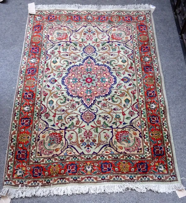 A pair of Tabriz rugs, Persian, the pale sage fields each with a pink medallion, matching spandrels, all with floral sprays; a madder palmette and vin