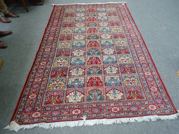 A Tabriz rug, Persian, the compartmented field, each with an arch design; a madder flowerhead border, 270cm x 168cm.