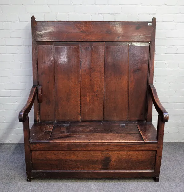 An 18th century oak plank back box seat open arm settle, 117cm wide x 144cm high.