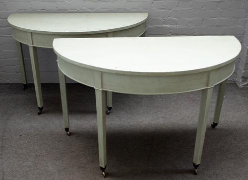 A pair of later painted George III mahogany demi-lune console tables on tapering square supports, 122cm wide x 24cm high, (2).