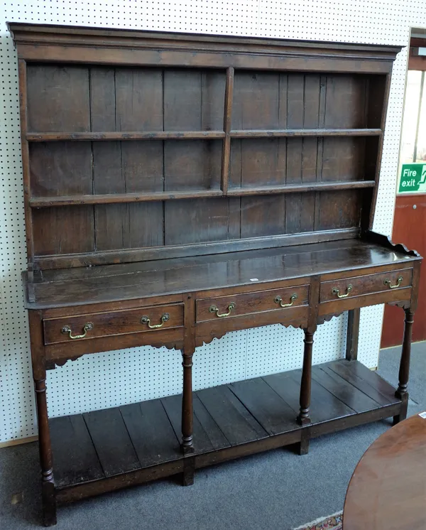 A mid-18th century oak dresser, the enclosed plate rack over three frieze drawers on turned supports, united by platform undertier, 182cm wide x 192cm