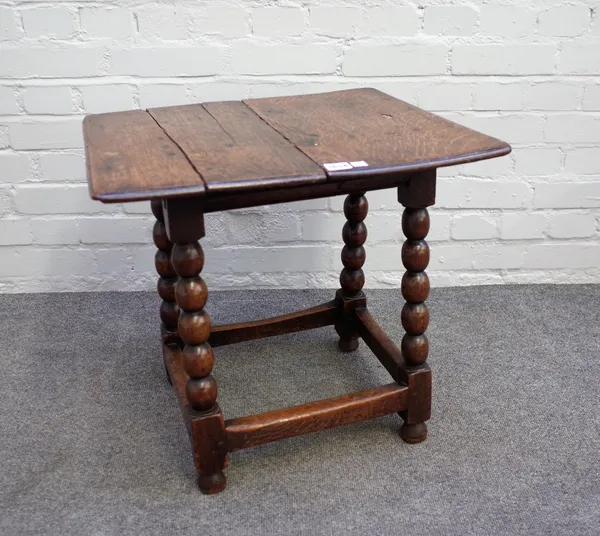 A 17th century oak low occasional table, the twin plank top on bobbin turned base, 55cm wide x 53cm high.