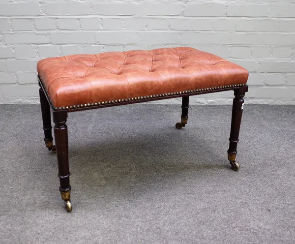 A rectangular brown leather upholstered footstool on 19th century turned rosewood supports, 69cm wide x 42cm high.