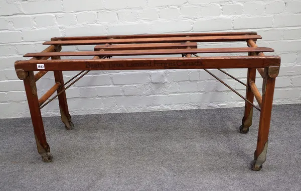 BT TUB BENCH FOR BEATTY BROS LIMITED FERGUS CANADA; a pitch pine and ash folding luggage stand, 108cm wide x 56cm high.