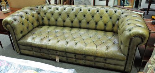 A green leather and brass studded button back Chesterfield sofa, 223cm wide x 73cm high.