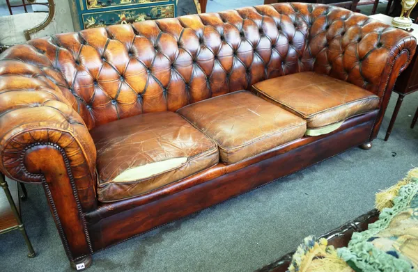 A brown leather Chesterfield sofa, on bun feet, 210cm wide x 78cm high.