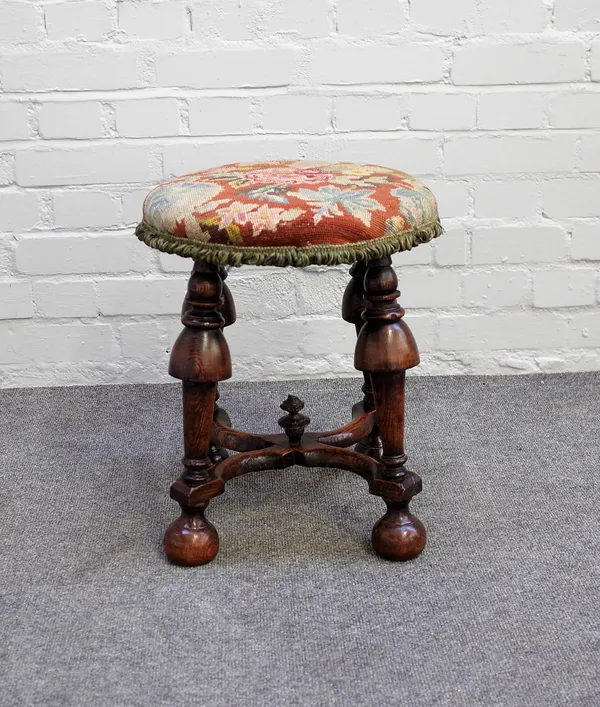 A William and Mary circular stool on four cup and cover supports, united by 'X' frame stretcher, 38cm diameter x 45cm high.