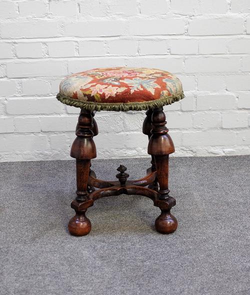 A William and Mary circular stool on four cup and cover supports, united by 'X' frame stretcher, 38cm diameter x 45cm high.