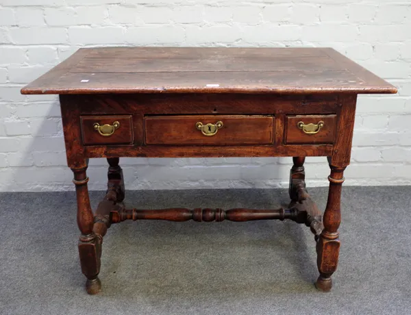 A 17th century and later elm side table, the plank angle adjustable top over three frieze drawers on baluster turned supports, 97cm wide x 69cm high.