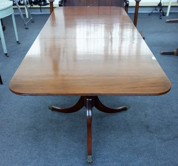 A Regency style mahogany twin pillar extending dining table on six downswept supports, with one extra leaf, 97cm wide x 182cm long x 230cm long fully
