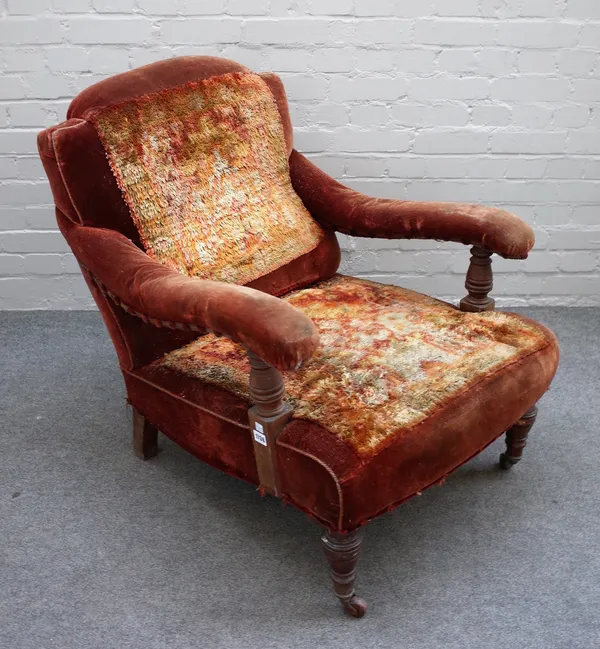 A Victorian low seat open arm easy chair on turned mahogany supports, 70cm wide x 82cm high.