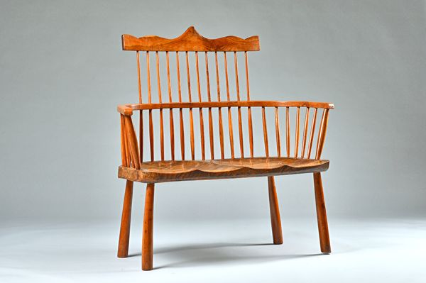 Possibly American, a 20th century elm and fruitwood comb back settle with double dished saddle seat on turned supports, 105cm wide x 100cm high. Illus