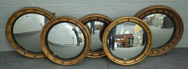 Five various Regency style gilt framed convex wall mirrors, circa 1900, the larger 51cm diameter.