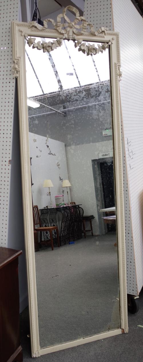 An early 20th century cream painted robing mirror with ribbon tied floral crest, 78cm wide x 230cm high.
