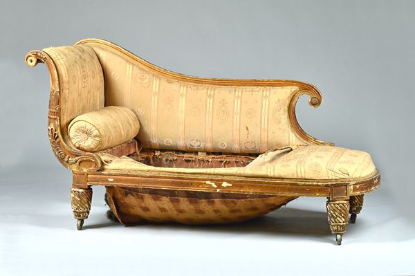 A George IV large gilt framed chaise longue, with foliate decorated frame around distressed upholstery, on spiral turned legs, 194cm wide x 100cm high