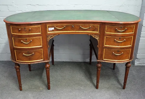 A Louis XVI style parcel gilt kingwood and walnut kidney shaped desk with seven drawers about the knee, 135cm wide x 76cm high.