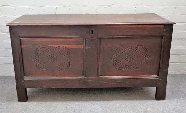 A 17th century oak coffer with single plank lid over twin panel front, 113cm wide x 59cm high.