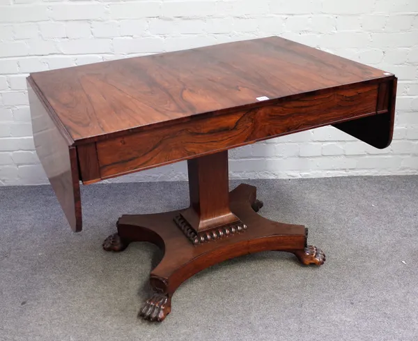 An early 19th century rosewood sofa table with pair of frieze drawers on flared column and four carved lions paw feet, 107cm wide x 75cm high.
