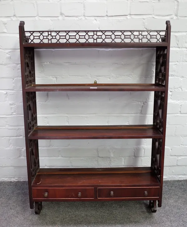 A 19th century mahogany four tier hanging wall shelf with fret carved decoration and pair of lower drawers, 67cm wide x 104cm high.