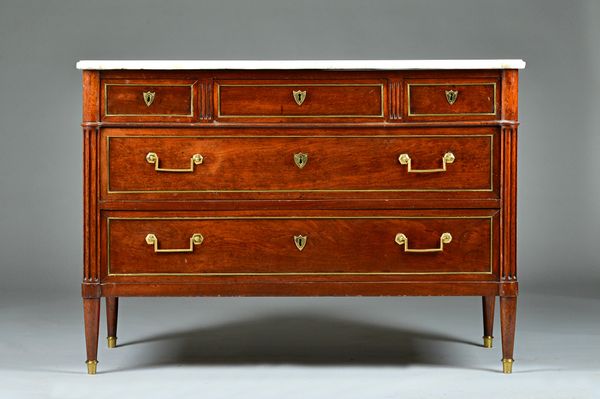 A French Directoire commode, the shaped marble top over a brass mounted mahogany base over three short and two long drawers on turned and fluted suppo