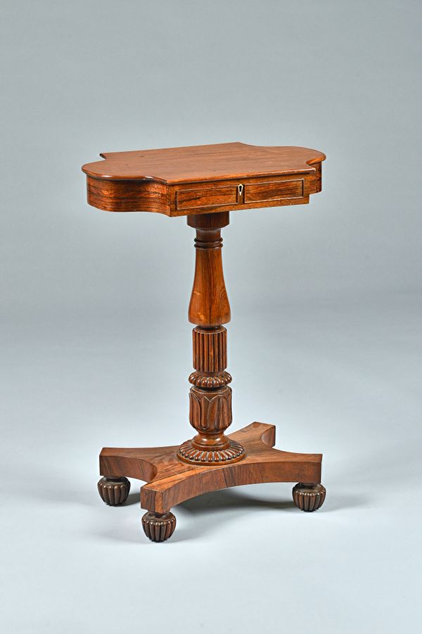 In the Manner of Gillows, a mahogany and rosewood side table, the shaped single drawer top on baluster turned and reeded column and quatrefoil platfor