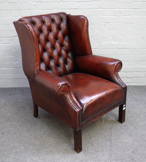 A George II style studded brown leather upholstered wingback armchair on block supports, 80cm wide x 97cm high.