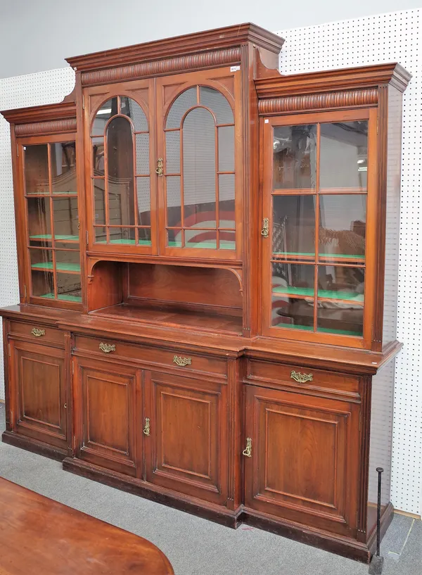 Jas Shoolbred & Co, a Victorian walnut breakfront library bookcase with four astragal glazed doors over three drawers and four panel cupboards, 246cm