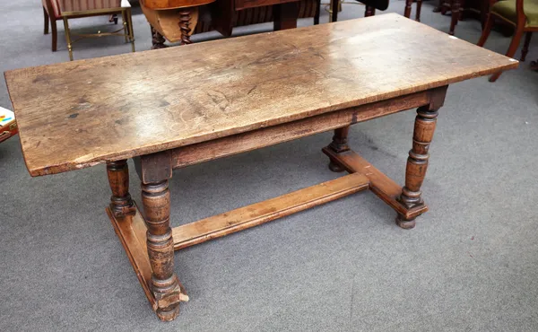 A 17th century style oak refectory table, the figured single plank top on turned supports, 70cm wide x 169cm long.