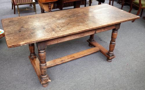 A 17th century style oak refectory table, the figured single plank top on turned supports, 70cm wide x 169cm long.