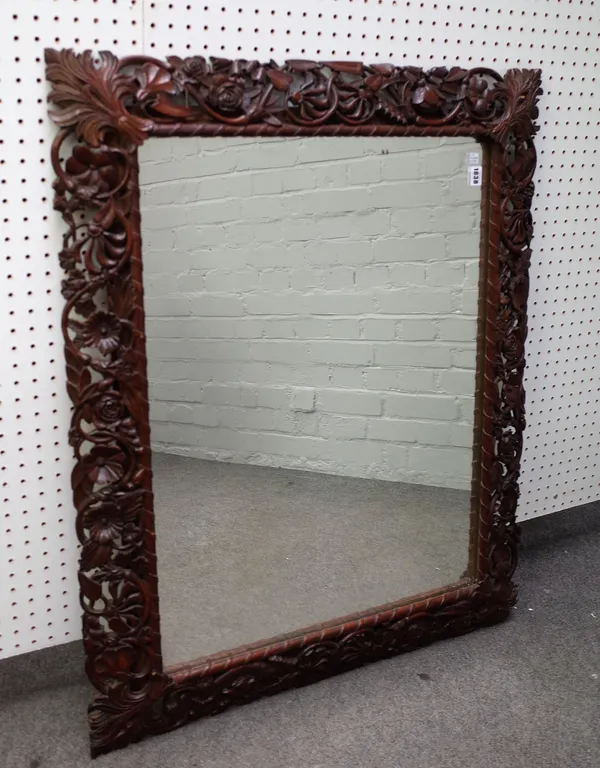 A 19th century oak mirror, the swept and pierced frame with floral carved decoration, 83cm wide x 104cm high.