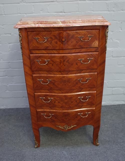 An 18th century French style petite commode, the serpentine marble top over a floral marquetry gilt metal mounted kingwood five drawer base, 59cm wide