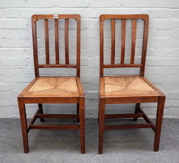 Probably Heals, a pair of mid-20th century oak side chairs with rush seats on tapering square supports, 44cm wide x 93cm high.