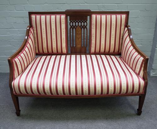 An Edwardian marquetry inlaid mahogany square back three piece suite comprising sofa, 121cm wide x 94cm high, and a pair of matching armchairs, 62cm w