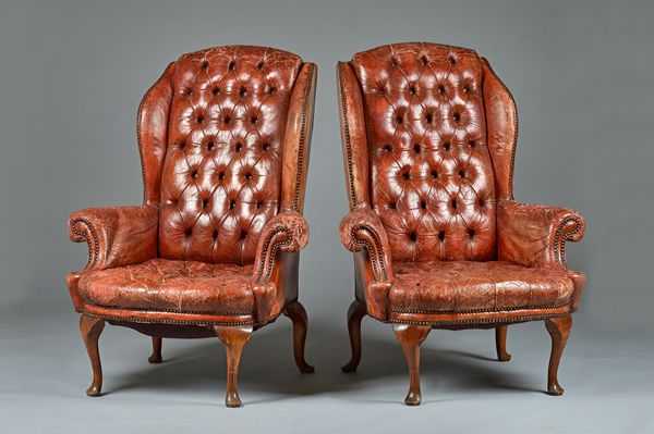 A pair of George I style button back red leather upholstered wingback armchairs on cabriole supports, 92cm wide x 123cm high. Illustrated