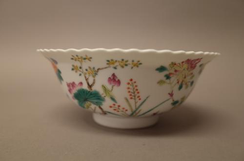 A Chinese famille-rose bowl, 19th/20th century, painted in the centre with a bat and two peaches, the exterior painted with flowering peony, prunus, c