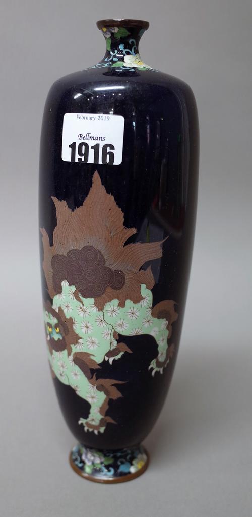 A Japanese cloisonné vase, Meiji period. of almost cylindrical form, worked with a shishi with a brocaded ball between floral borders against a midnig