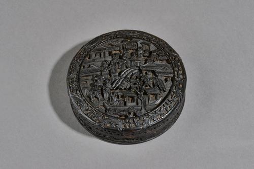 A Chinese export tortoiseshell circular snuff box and cover, 19th century,  the cover and underside of base finely carved with figures, a boat, trees
