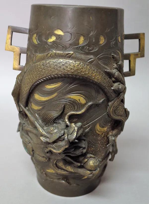 A Japanese bronze two-handled vase, Meiji period, of swollen cylindrical form, decorated in high relief and picked out in gilding with a dragon above