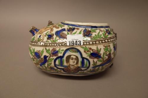 A Qajar pottery begging bowl (kashkul), late 19th century, painted with four head and shoulder portrait panels against a ground filled with birds, a d