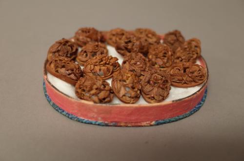 A group of sixteen carved nuts, late 19th/early 20th century, two in the round and the rest of oval section, each intricately carved and pierced with