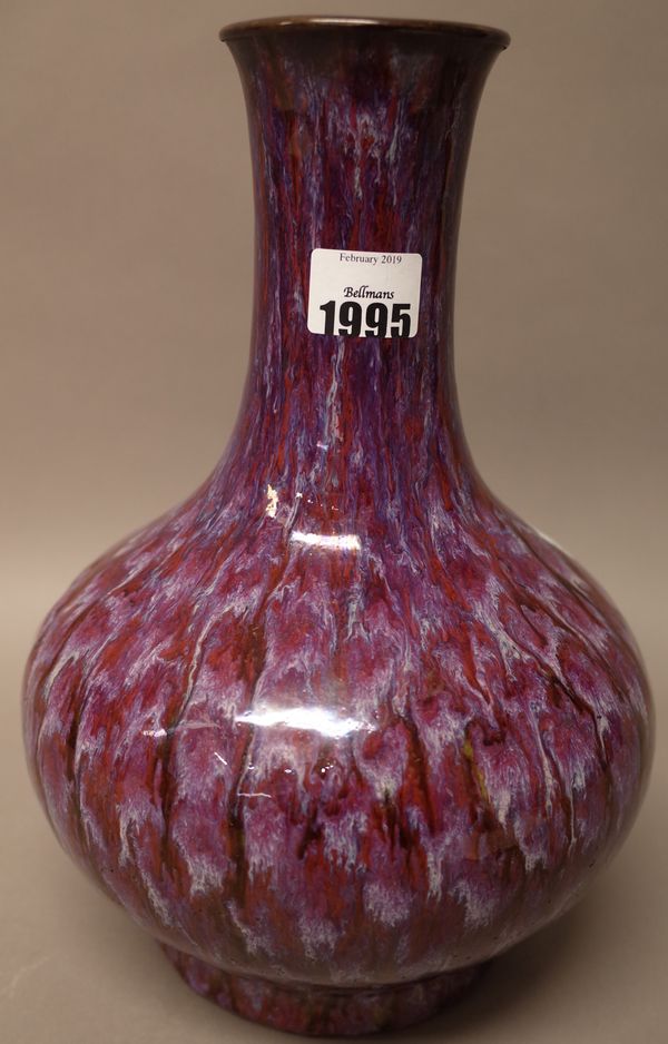 A Chinese flambé glazed bottle vase, 19th/20th century, streaked in purple, red and lavender, the mouth with metal rim, 28.5cm. high.