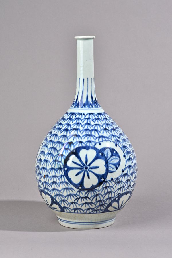 A tall Arita blue and white bottle vase, Edo period, the pear shaped body painted with circular flower medallions against a ground filled with bamboo