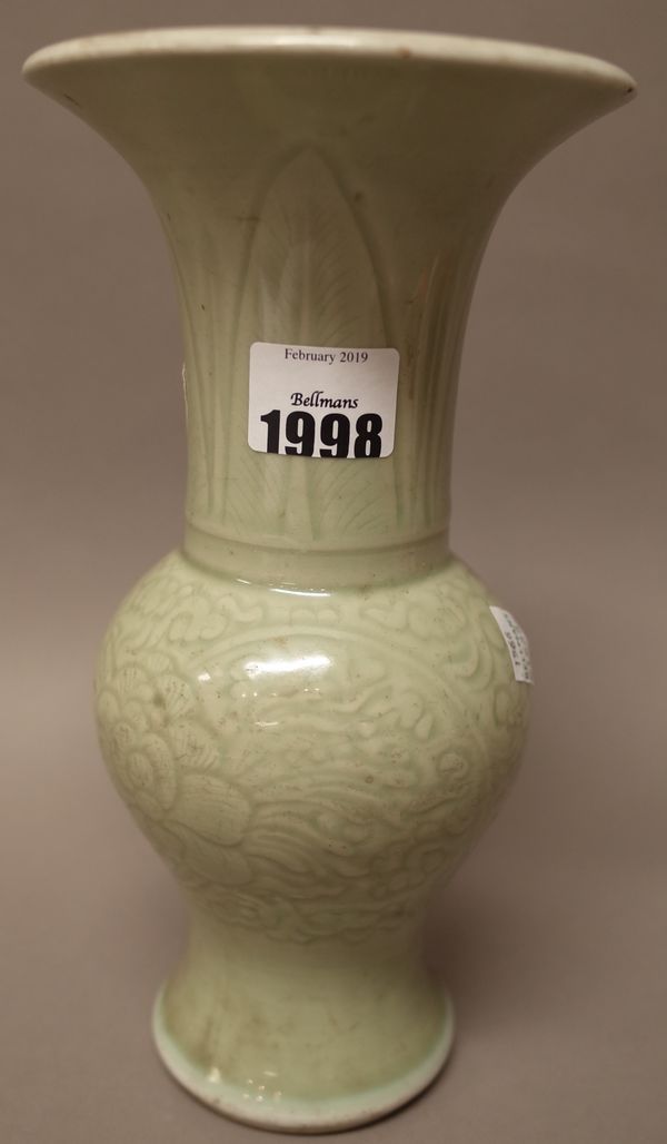 A Chinese celadon glazed yenyen vase, probably 18th century, carved with peony flowers beneath stiff leaves, covered in a  pale celadon glaze,  24cm.