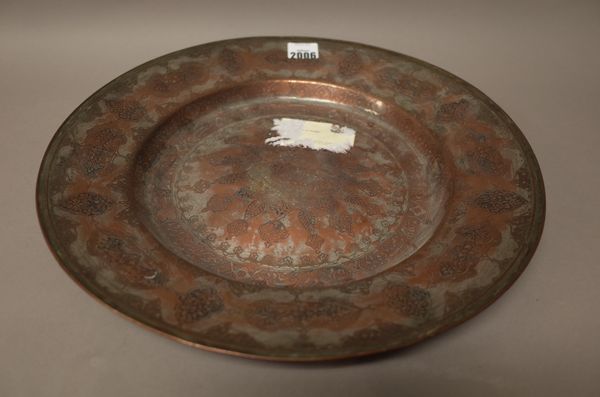 An Indian engraved tinned copper dish, probably late 17th century, engraved with foliate medallions, 37.5cm. diameter.