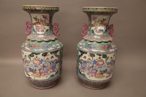 A pair of Chinese famille-rose two-handled vases, 19th century, each cylindrical body painted with two panels of the Immortals, the necks with smaller