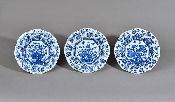 Three Chinese blue and white lobed plates, Kangxi, each painted in the centre with birds and insects hovering above flowers and rocks, the lobed borde