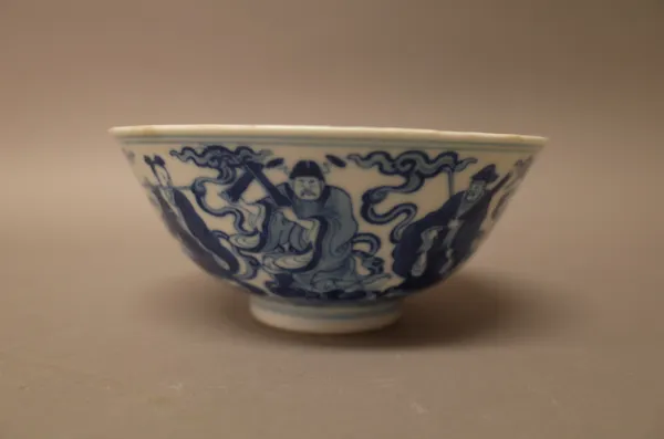 A Chinese blue and white `Immortals' bowl, Qianlong, painted around the exterior with the eight  Immortals holding their respective attributes, standi